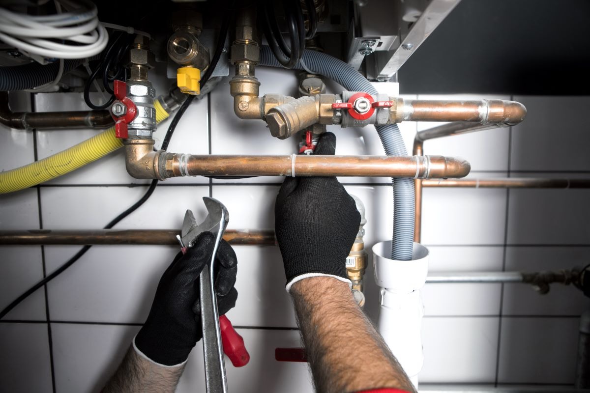 plumber fixing pipes with gloves