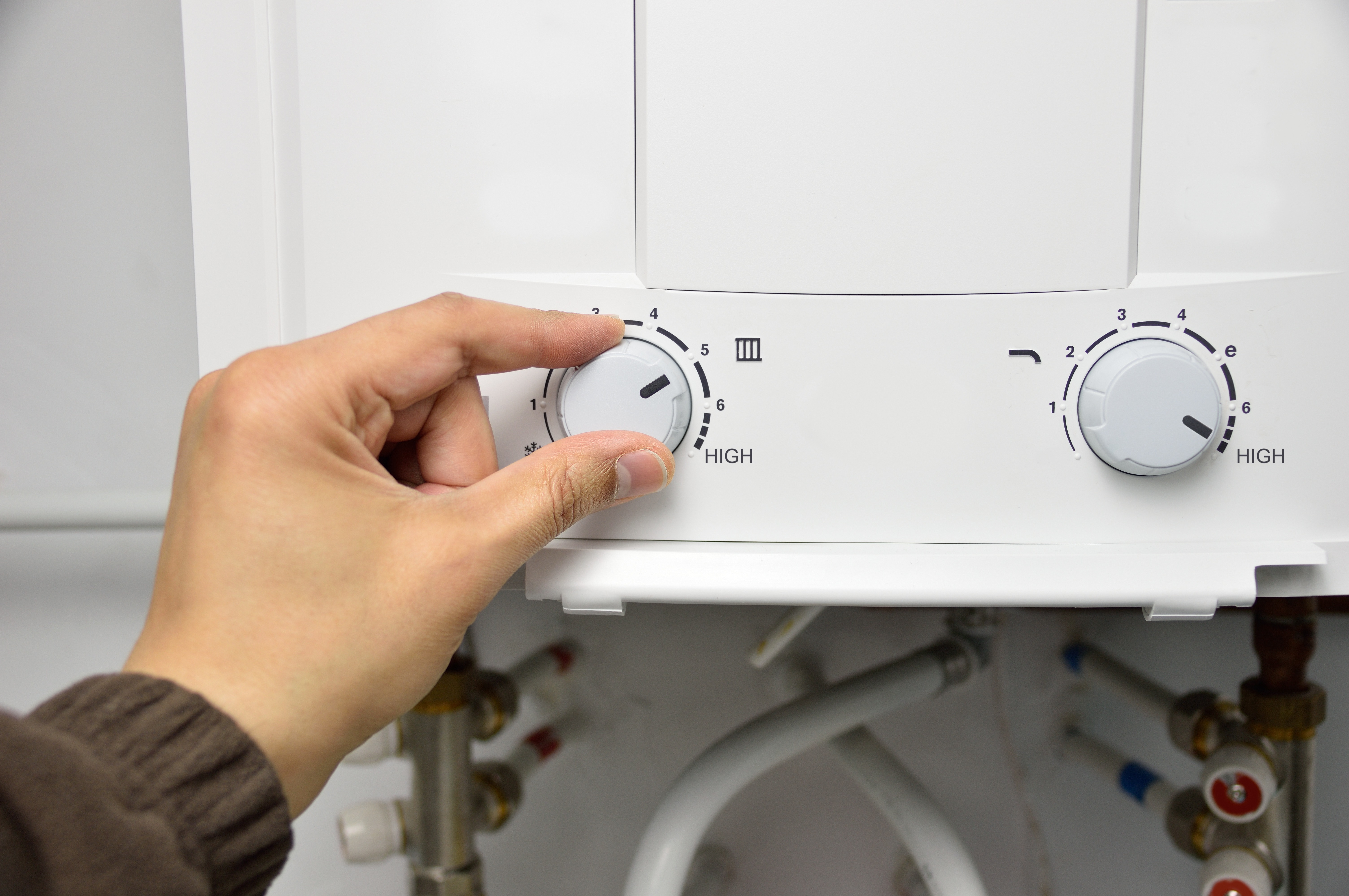 hand adjusting temperature of tankless water heater